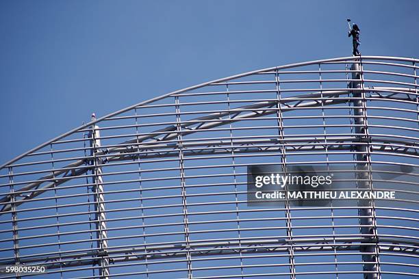 Alain Robert, a French urban climber aka Spiderman, takes a selfie as he stands on top of a building of La Defense business area, on August 31, 2016...