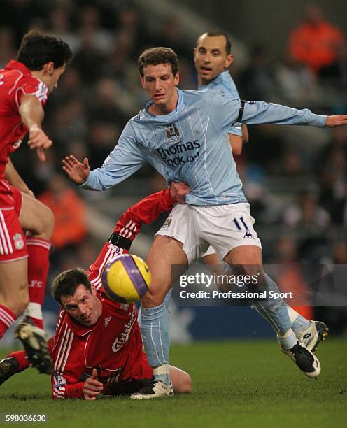 Elano of Manchester City is held by Jamie Carragher of Liverpool during the Barclays Premier League match between Manchester City and Liverpool at...