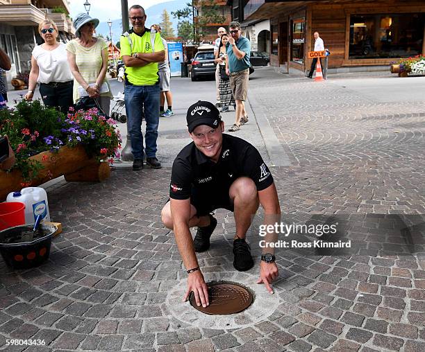 Danny Willett of England cementes his 'Walk of Fame' plaque into a footpath in Crans-sur-Sierre during the pro-am event prior to the Omega European...