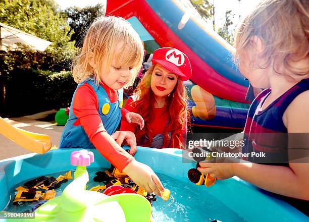 Singer Christina Aguilera watches her daughter Summer Rain Rutler play with toys during the second birthday party for Christina Aguilera's daughter...