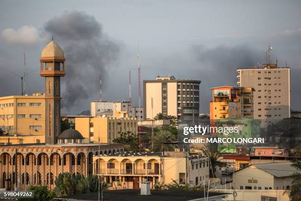 This picture taken on August 31, 2016 shows smoke billows in the skyline of Gabonese capital Libreville as supporters of opposition leader Jean Ping...