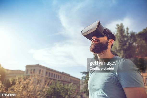 mann spielt augmented reality mit vr-headset - stadium or arena or coliseum or colosseum or ring exterior or outdoor stock-fotos und bilder