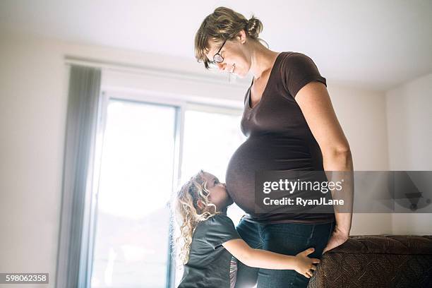 schwangere frau mit liebevollem kind - belly kissing stock-fotos und bilder