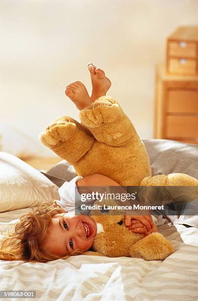 young girl (1-3 years) playing with teddy bear on bed - 2 3 years foto e immagini stock
