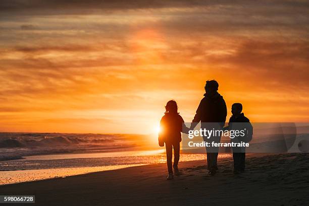 夕暮れ時にビーチで歩く家族 - ハンプトン ストックフォトと画像