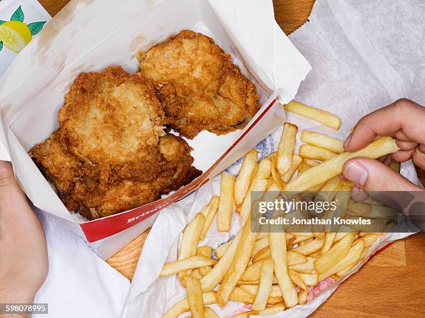 men eating fast food, fries chicken and fries - gefrituurde kip stockfoto's en -beelden