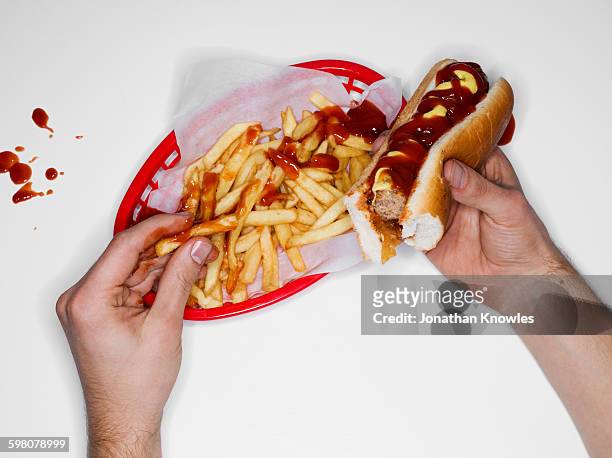 messy eating, hot dog and fries, overhead view - hot dog schnellimbiss stock-fotos und bilder