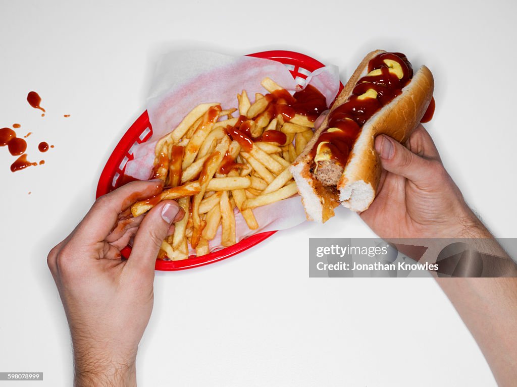 Messy eating, hot dog and fries, overhead view