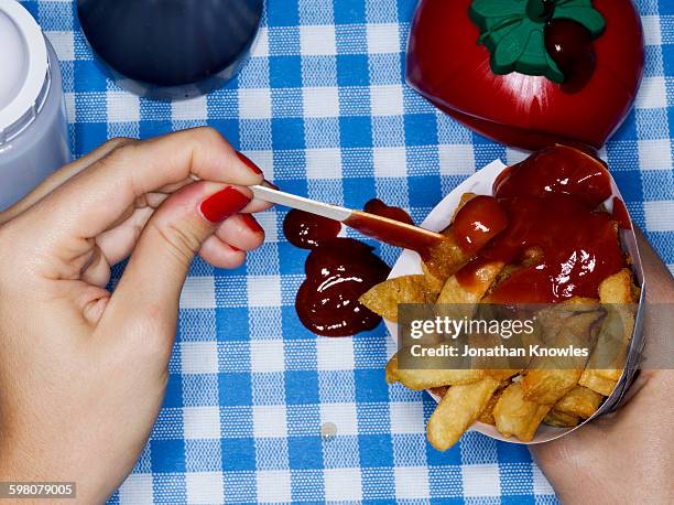 female holding chips with ketchup, messy - tomato sauce stock pictures, royalty-free photos & images