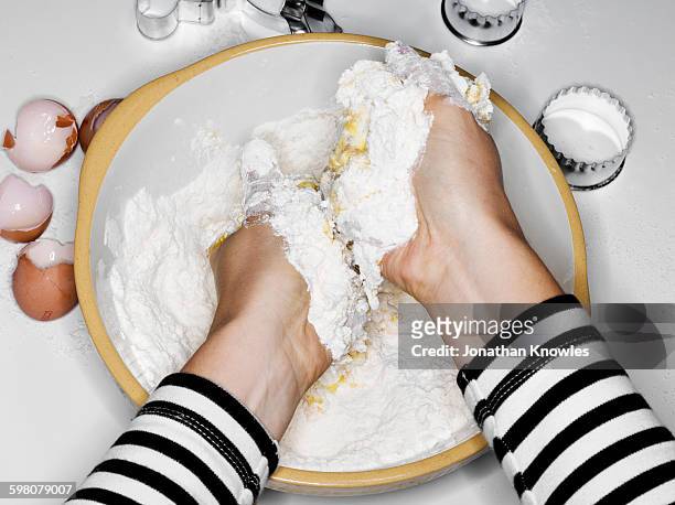 female mixing flour with eggs with hands - combining stock pictures, royalty-free photos & images