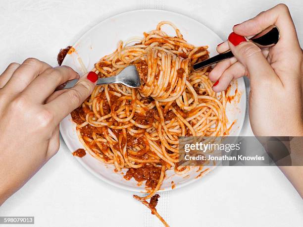 female eating spaghetti, overhead view - spaghetti foto e immagini stock