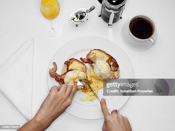 female eating eggs benedict, overhead view - eggs benedict stock pictures, royalty-free photos & images