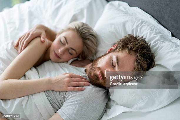 couple sleeping in bed - matras stockfoto's en -beelden