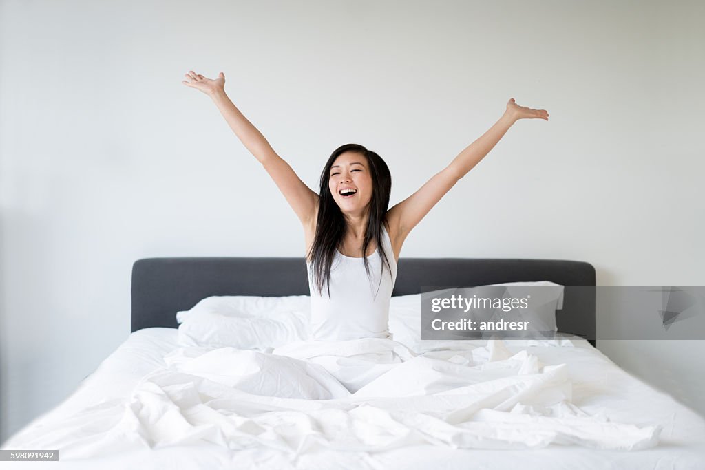 Asian woman yawning in bed