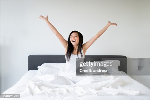 Asian woman yawning in bed Asian woman yawning in bed