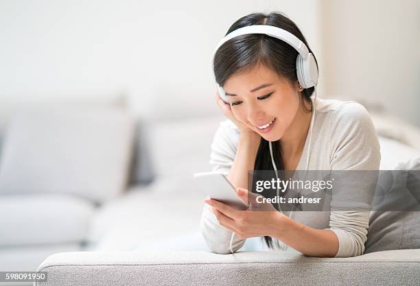 woman listening to music at home - smartphone video stock pictures, royalty-free photos & images