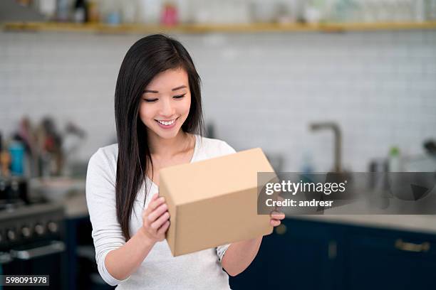 asian woman getting the mail at home - open gift box stock pictures, royalty-free photos & images