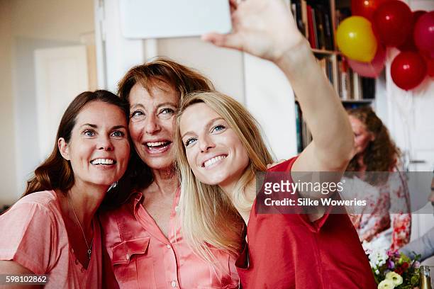 good friends taking a self-portrait with a smartphone at a party - 40 birthday foto e immagini stock