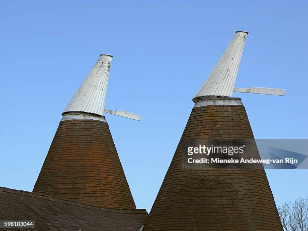 chimneys of hop or oast houses: circular distinctive buildings with conical roofs in tudeley, county kent, england, united kingdom - mieneke andeweg stock pictures, royalty-free photos & images