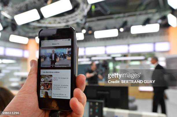 Live stream on a smartphone shows Franceinfo's French journalist Louis Laforge speaking, during the first Franceinfo's TV broadcast, on August 31...