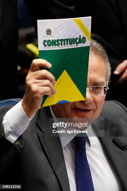 President of the Senate Renan Calheiros holds the federal constitution of Brazil at impeachment proceedings of President Dilma Rousseff August 31,...