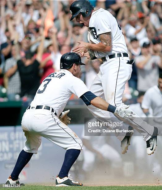 JaCoby Jones of the Detroit Tigers jumps into the arms of Ian Kinsler of the Detroit Tigers after scoring the winning run against the Chicago White...