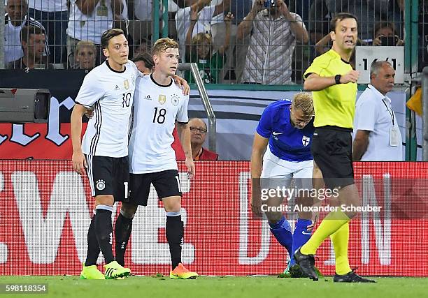 Mesut Oezil of Germany celebrates the second goal with team mate Max Meyer, an own goal by Paulus Arajuuri of Finland during the International...