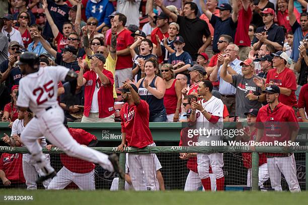 Teammates react as Jackie Bradley Jr. #25 of the Boston Red Sox rounds first base after hitting an RBI double during the eighth inning of game...