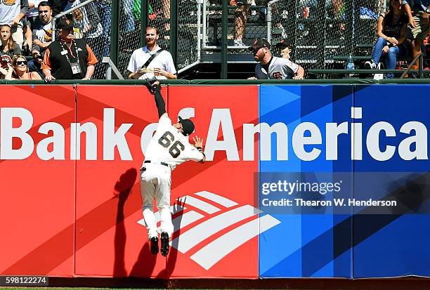 Gorkys Hernandez of the San Francisco Giants leaps into the wall to make the catch while taking a hit away from Paul Goldschmidt of the Arizona...
