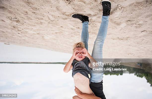 exploring the world upside down - boy exploring on beach stock-fotos und bilder