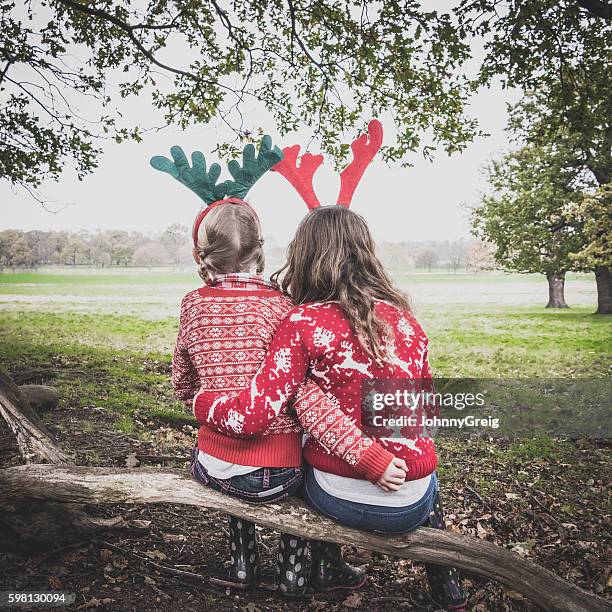 Portrait of two girls wearing antlers, arms around each other