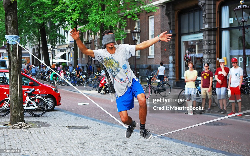 Blinfolded man walking on a tightrope