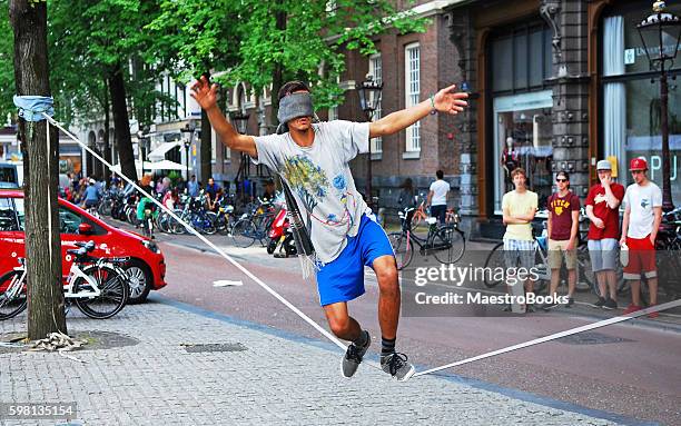 blinfolded man walking on a tightrope - entertainment occupation stock pictures, royalty-free photos & images