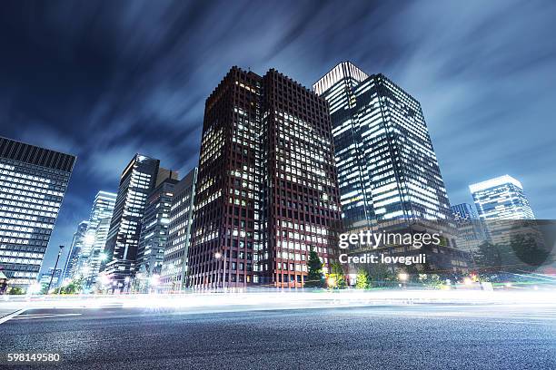 skyscrapers with busy traffic at night - cityscape road stock pictures, royalty-free photos & images