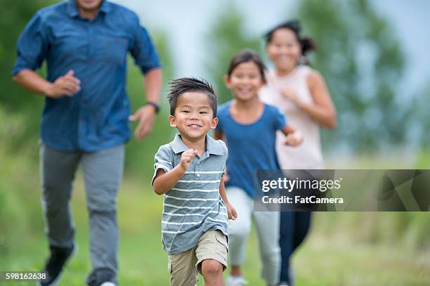 playing tag outside on a sunny day - family playing tag stock pictures, royalty-free photos & images