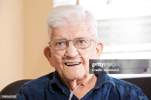 hombre mayor sonriente que usa oxígeno - enfermedad-pulmonar-obstructiva-crónica fotografías e imágenes de stock