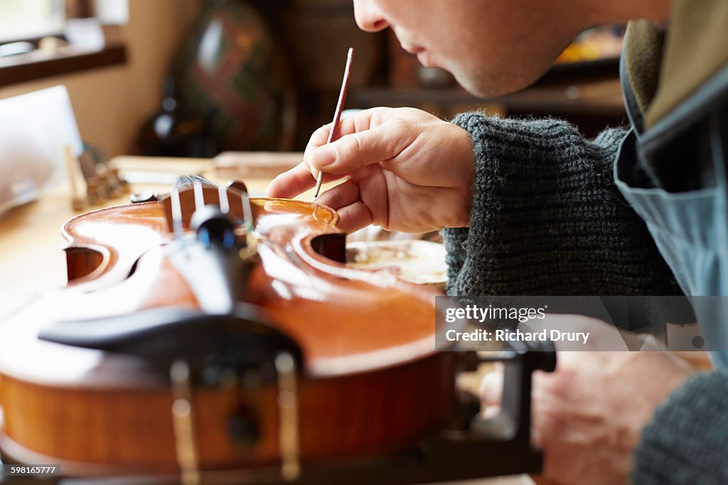 Retouching varnish in violin repair workshop