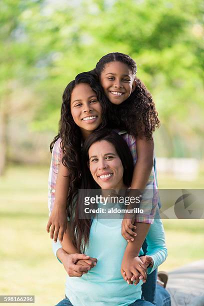 playful latin mother and daughters smiling at camera - cute mexican girl 個照片及圖片檔