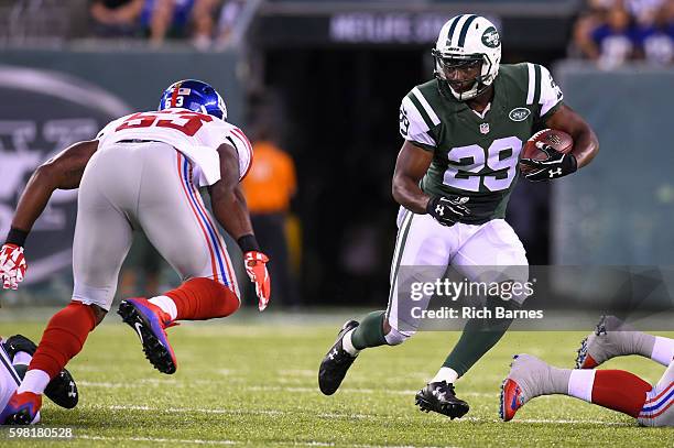Matt Forte of the New York Jets runs with the ball as Jasper Brinkley of the New York Giants defends during the first quarter at MetLife Stadium on...