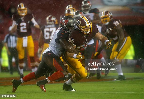 Outside linebacker Adarius Glanton of the Tampa Bay Buccaneers breaks up a pass intended for tight end Logan Paulsen of the Washington Redskins...