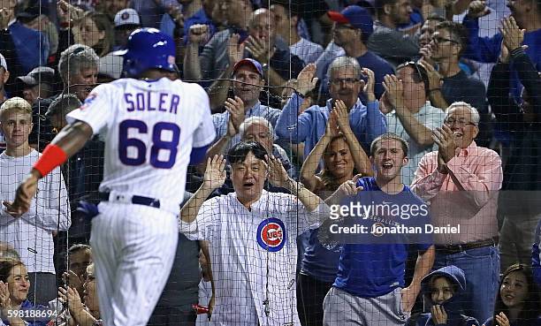 Fans cheer as Jorge Soler of the Chicago Cubs scores a run in the 6th inning on a single by Jason Heyward against the Pittsburgh Pirates at Wrigley...