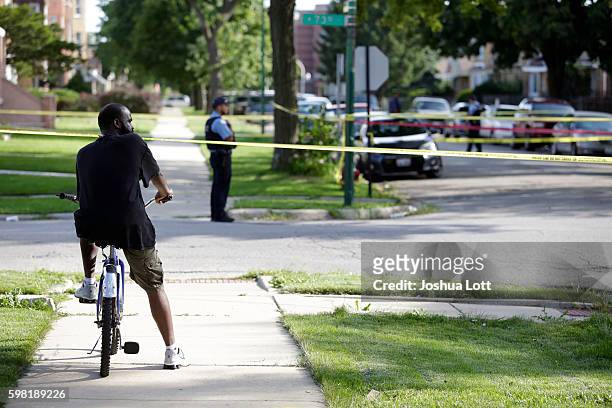 Man on his bike looks a crime scene where a man was fatally shot in the head in the 7300 block of South Rockwell Street on August 31, 2016 in...