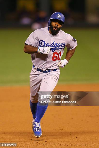 Andrew Toles of the Los Angeles Dodgers celebrates as he rounds the bases after hitting a go-ahead grand slam in the ninth inning against the...