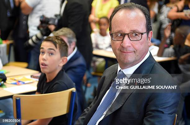 French President Francois Hollande sits in a classroom during a visit at the high school Jean Rostand for the first day of the starting of the school...