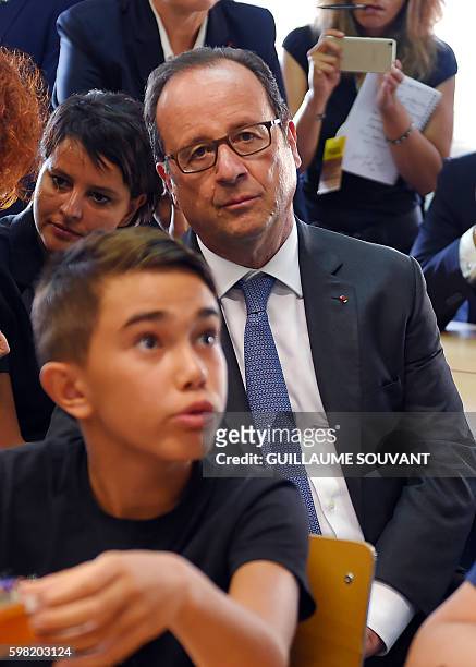 French President Francois Hollande sits with French Minister of Education Najat Vallaud-Belkacem in a classroom during a visit at the high school...
