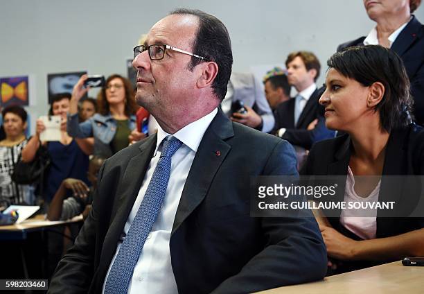 French President Francois Hollande sits with French Minister of Education Najat Vallaud-Belkacem in a classroom as they look on during a visit at the...