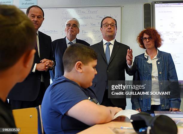 French President Francois Hollande , flanked by director of the school , speaks to a classroom during a visit at the high school Jean Rostand for the...