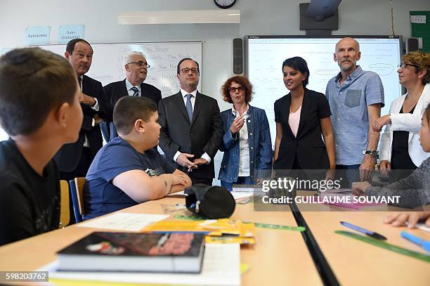 French President Francois Hollande and French Minister of Education Najat Vallaud-Belkacem look on as the director of the school speaks during a...