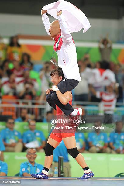 Day 12 Eri Tosaka of Japan celebrates her dramatic last minute victory against Mariya Stadnik of Azerbaijan carrying coach Kazuhito Sakae around the...