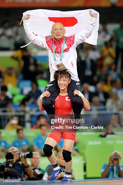 Day 12 Eri Tosaka of Japan celebrates her dramatic last minute victory against Mariya Stadnik of Azerbaijan carrying coach Kazuhito Sakae around the...